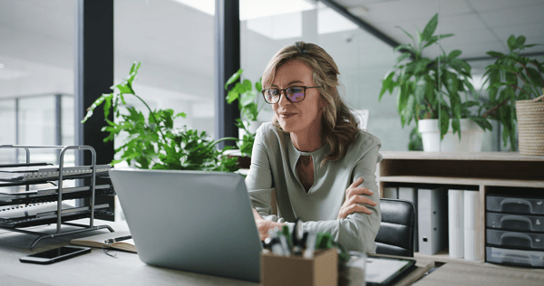 Frau sitzt im Büro vor dem Laptop