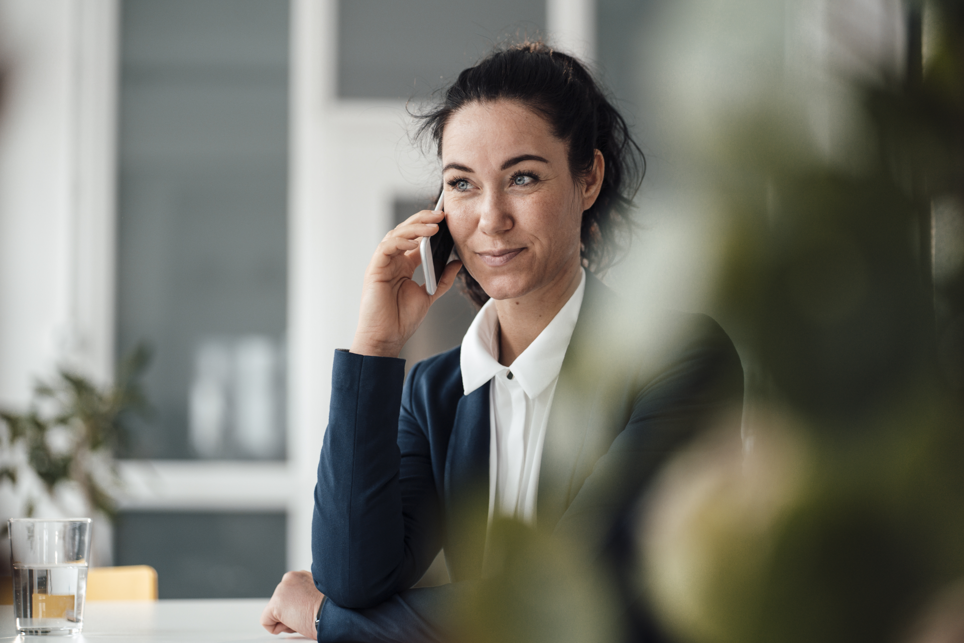 Eine Businessfrau führt ein Telefongespräch in einem modernen Büro.
