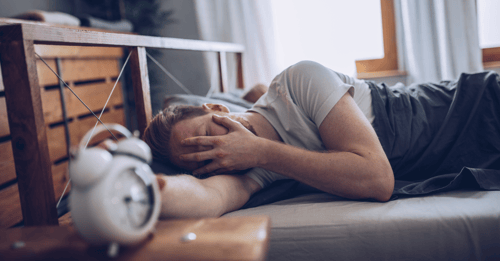 mann_mit_wecker_im_bett-1